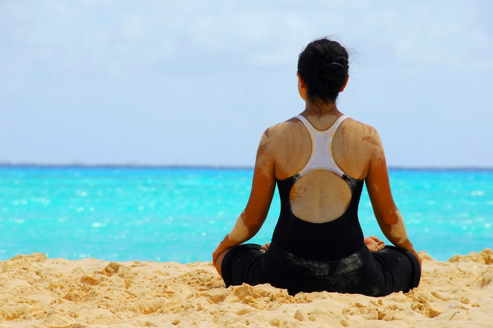 A traveller meditating beside the ocean